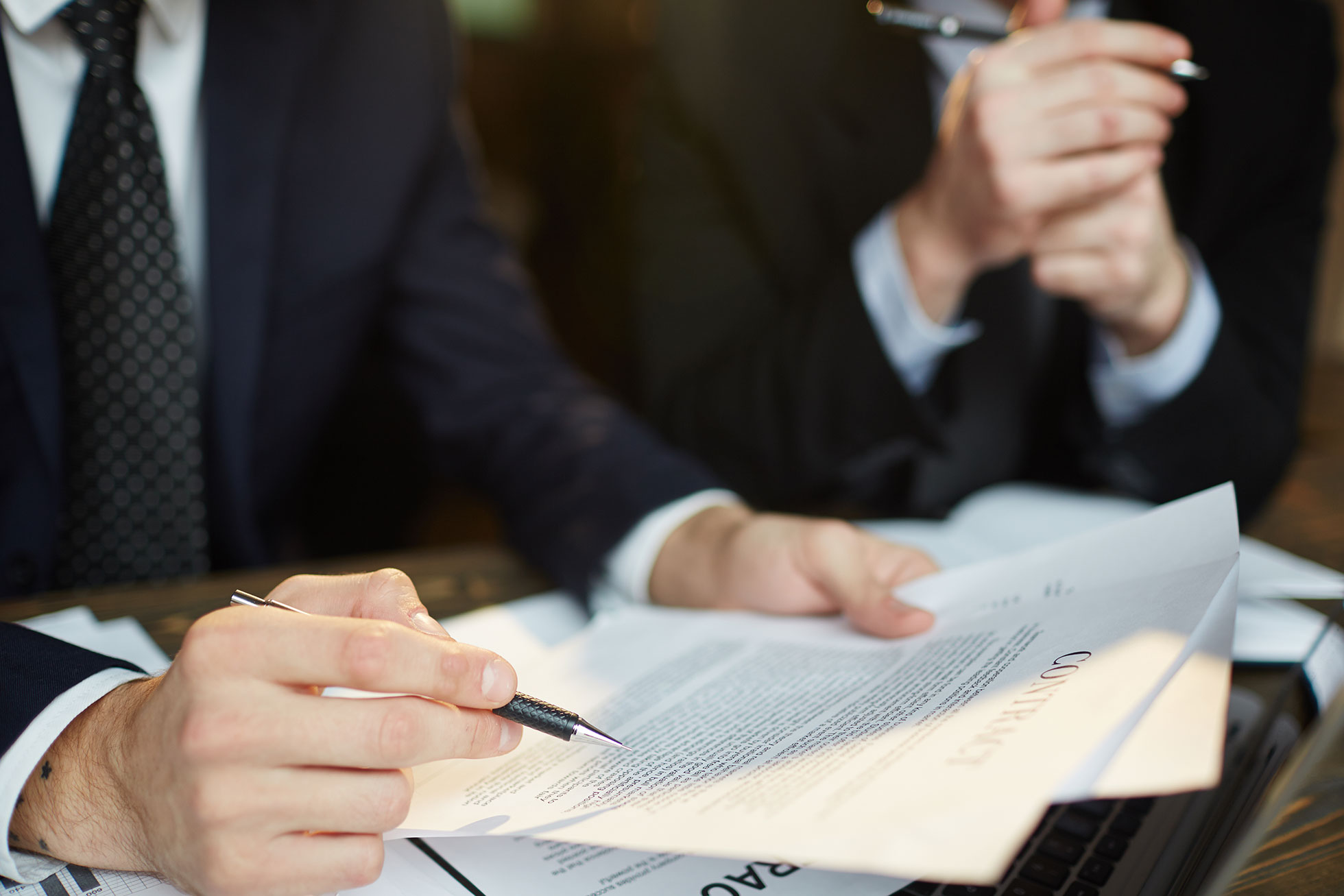 Executivos analisando um contrato sobre a mesa de reunião